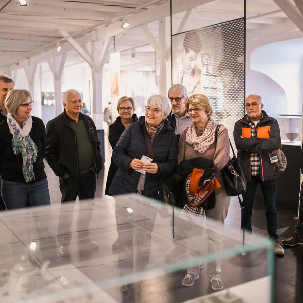 Gruppe von Besuchern vor einer Vitrine im Museum